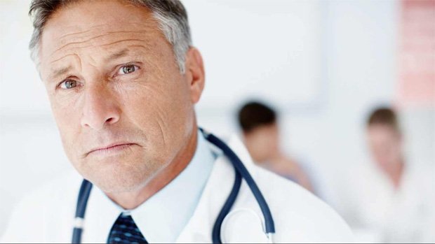 Врач в белом халате и стетоскопом на фоне других врачей