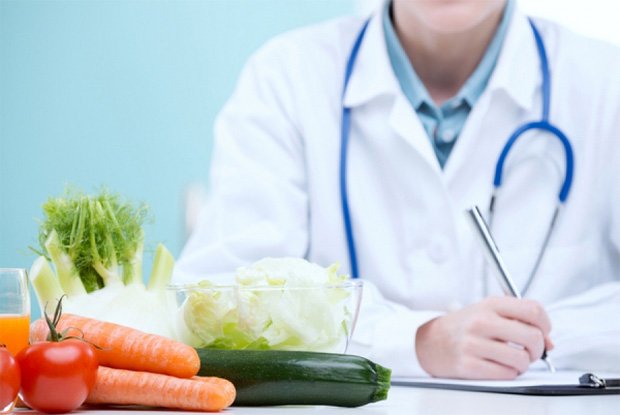 На столе лежат полезные овощи на фоне врача, который записывает диагноз