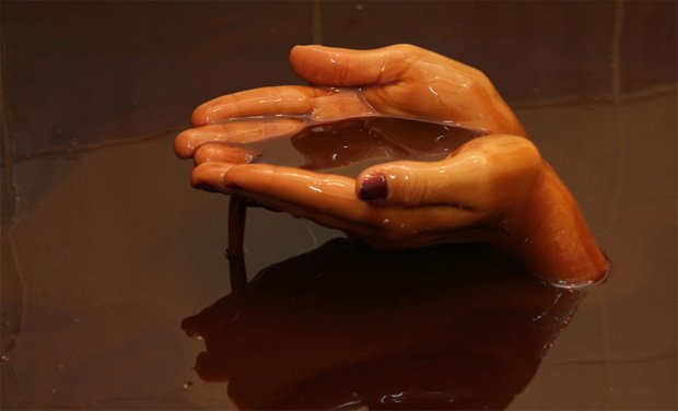 Из нафталановой ванный человеческие руки держат немного жидкости