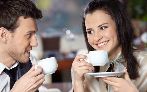 Молодая девушка с парнем пьют кофе из белых чашек