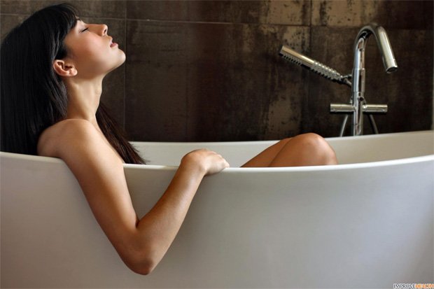 Обнаженная девушка сидит в овальной ванне
