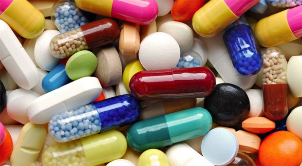 Различные виды лекарств в таблетках и капсулах на столе