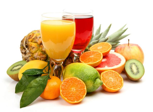 На столе два стакана со свежевыжатым соком и витаминизированные фрукты