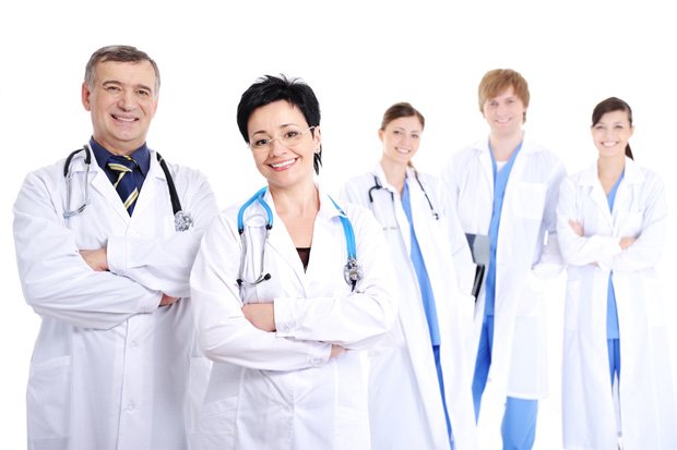 Пятеро врачей клиники в белых халатах улыбаются