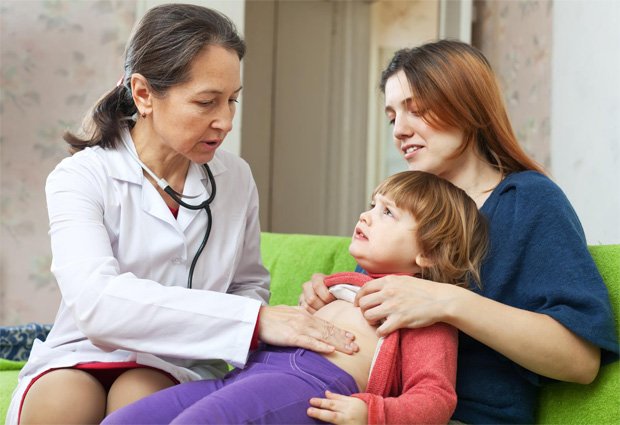 Женщина врач осматривает на дому ребенка для диагностики