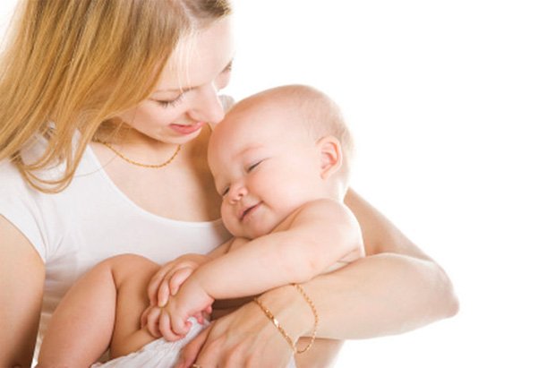 Молодая мамочка держит своего ребенка на руках